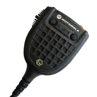 Zvětšený detail Motorola GMMN1111 reproduktoru s mikrofonem, viditelný oranžový PTT spínač, logo Motorola a symbol ATEX certifikace.