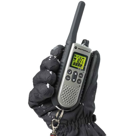 Zasněžená ruka v černé rukavici drží radiostanici Motorola TLKR T7 PMR446 v šedé barvě s černými detaily. Zobrazený displej svítí zeleným podsvícením.