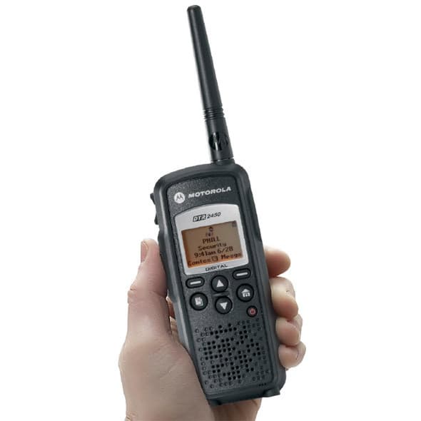 Radiostanice Motorola DTR2450 digitální držená v levé ruce, s jemně nakloněným displejem zobrazujícím detail zpráv přijatých digitální cestou.