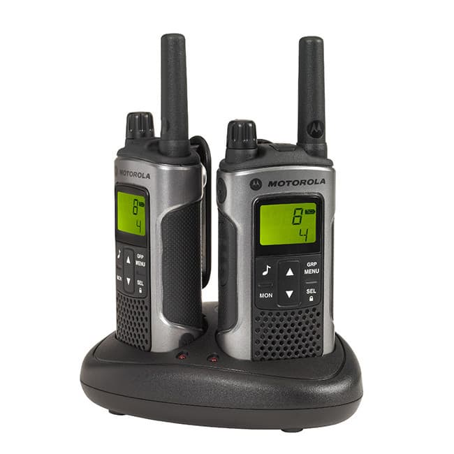 Dvě radiostanice Motorola TLKR T80 PMR446 v šedé barvě umístěné v černé dobíjecí stanici. Obě mají zapnutý displej.