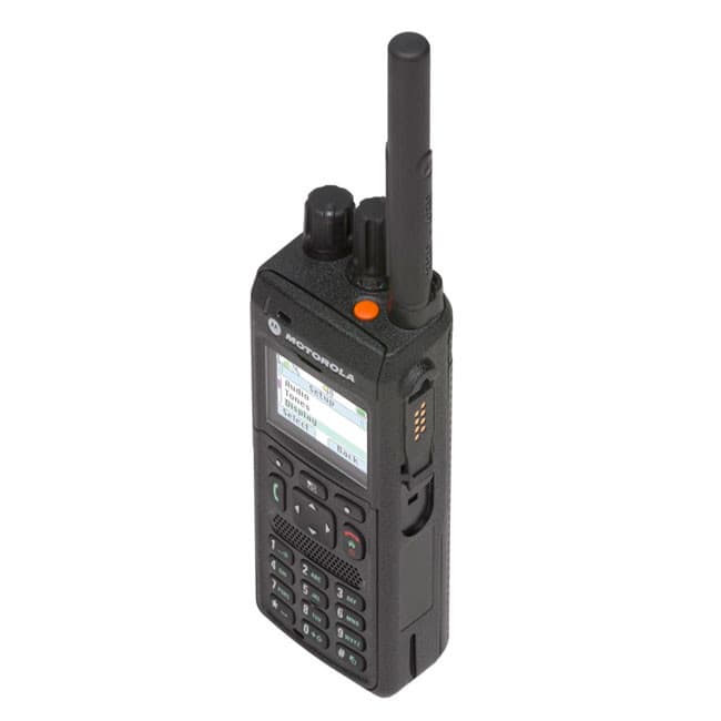 Pohled na MTP3550 UHF TETRA z pohledu shora doprava zezadu, s viditelnými kontakty pro nabíjení a oranžovým nouzovým tlačítkem.