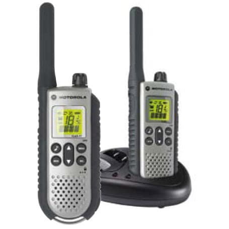Dvě stříbrná rádia Motorola TLKR T7 PMR446 v pohledu zepředu, jedno z nich v dobíjecí stanici. Obě mají černou anténu a ovládací prvky, displej svítí zeleně.